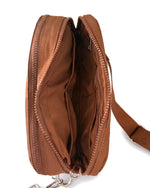 Inside the Chocolate A5 crossbody bag, opened flat to show the pockets