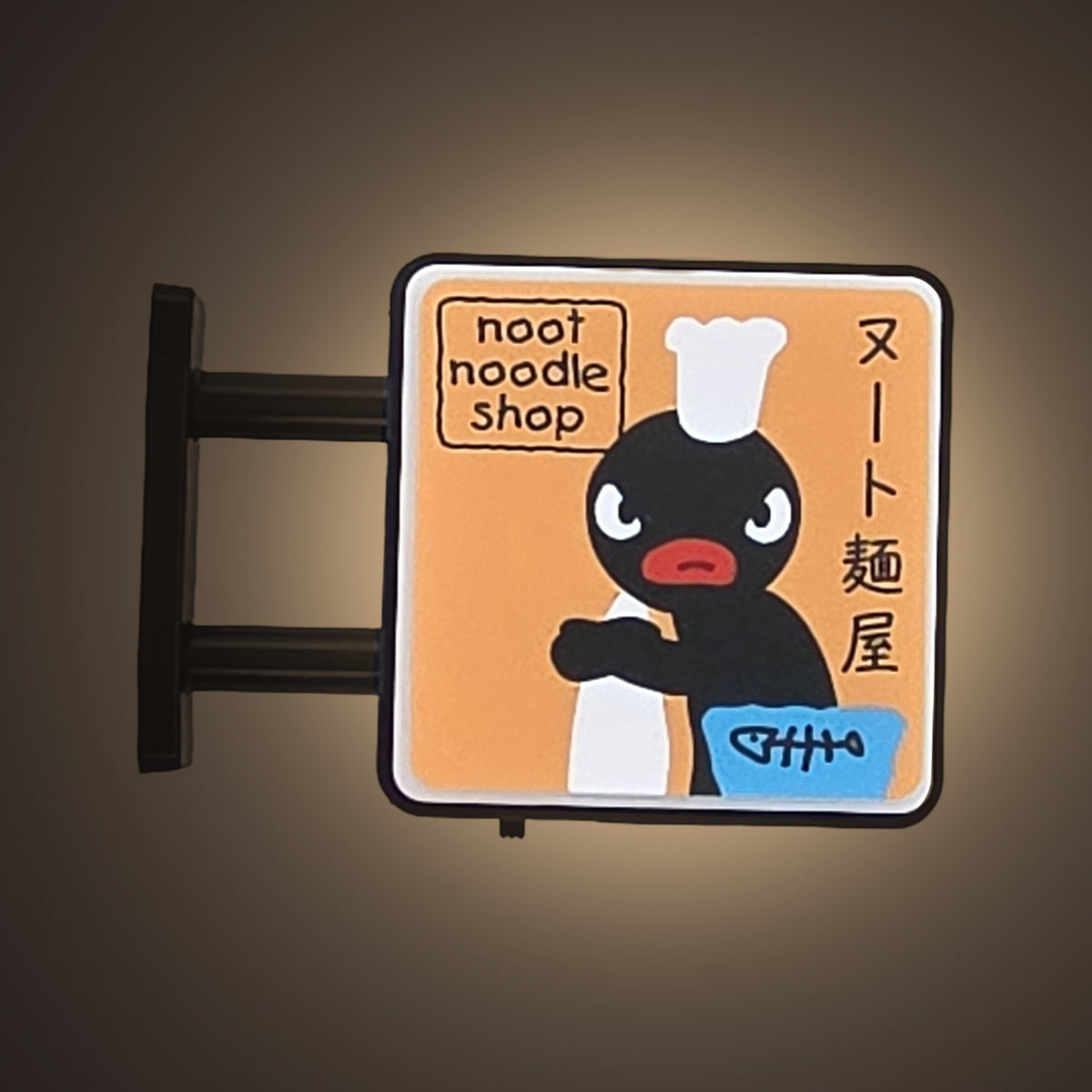 Noot Noodle Magnet Light by Pinbuds, lit up in the dark