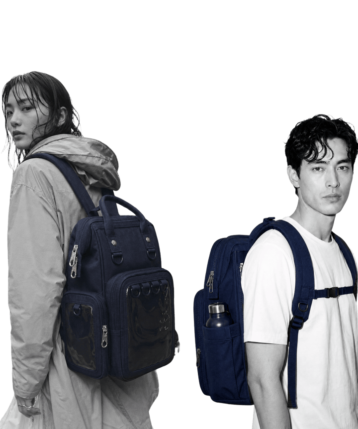 Two people wearing the Pinbuds 15 inch Navy Anti-Theft ITA backpack