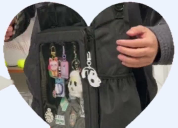 Clipping charms onto the lobster clasps by the window zip of the 15 inch Cotton ITA bag